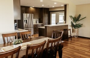 A modern kitchen with dark wood cabinets, stainless steel appliances, and a central island.
