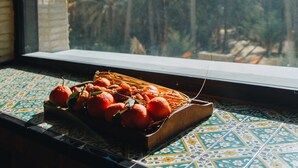 A window with a view of palm trees and oranges on a tiled table. - DAR EBBA  (Degache)