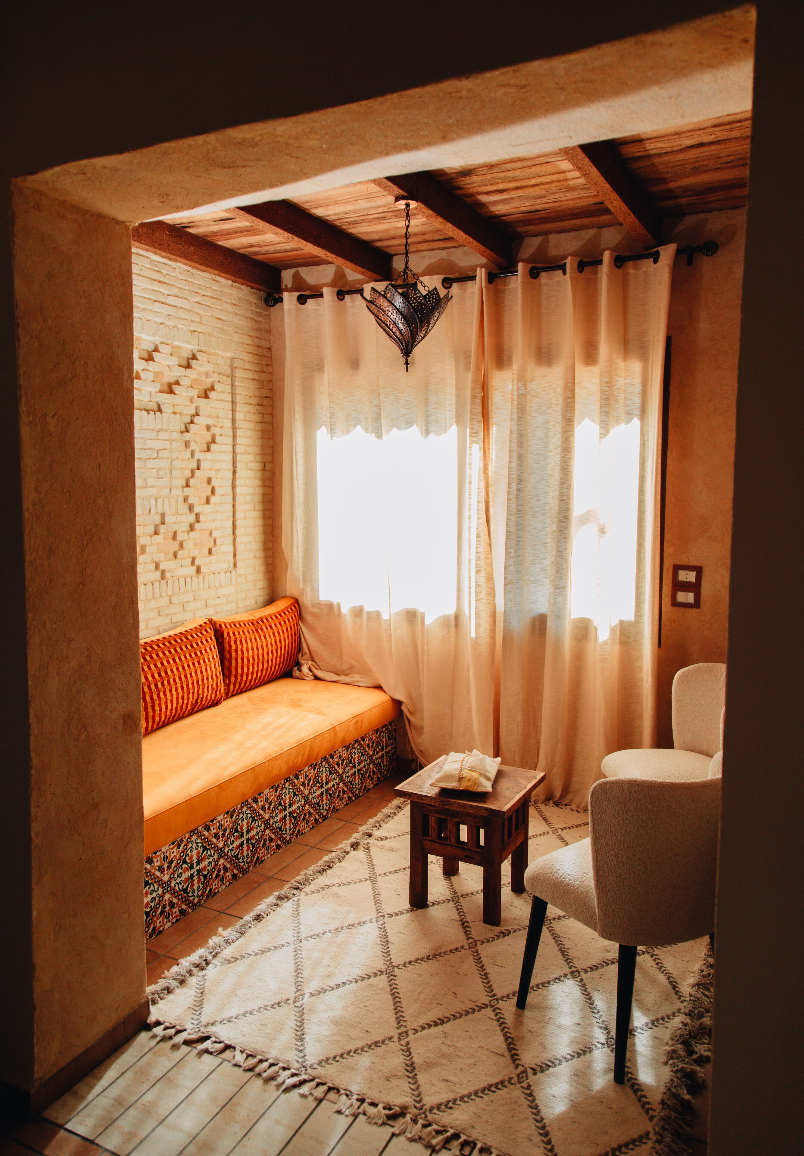 A cozy room with a sofa, a chair, a small table, and a patterned rug.
