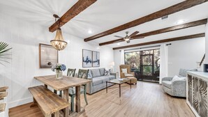 A spacious living area with a wooden dining table, a sofa, and a coffee table.