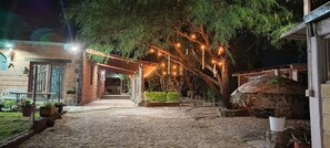 A courtyard with a stone pathway, a pergola with string lights, and a rustic stone oven. - Casa Spa Ikal, tranquility, pool, temazcal, 10 minutes from Tequisquiapan.  (La Llave)