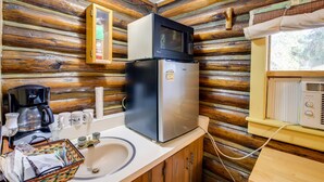 Une cuisine compacte équipée d’un réfrigérateur, d’un four à micro-ondes, d’une machine à café et d’un évier.