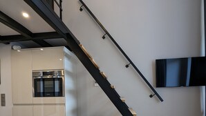 A modern kitchen with a built-in oven and a dining area with a marble table.