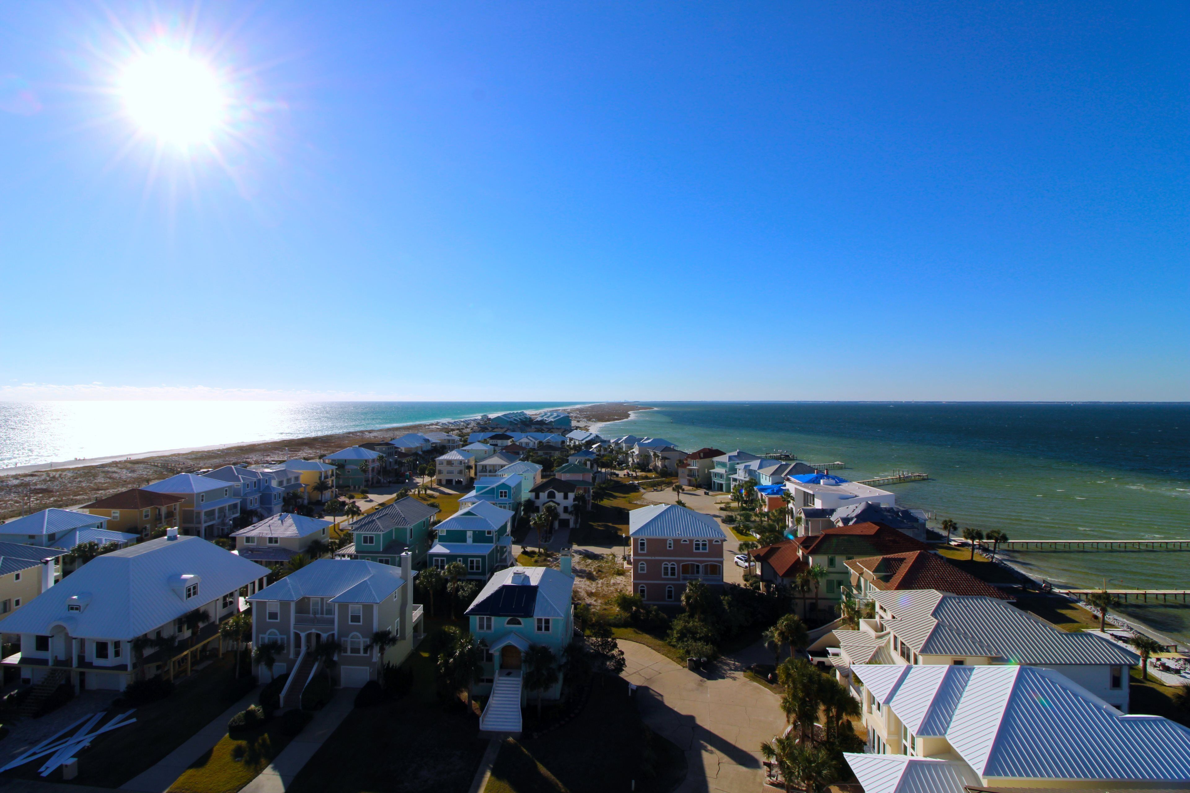 Zona residencial costera con casas, un muelle y una playa.