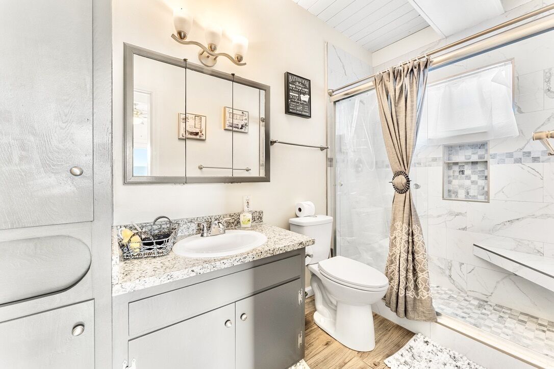 A modern bathroom with a sink, toilet, and shower area.