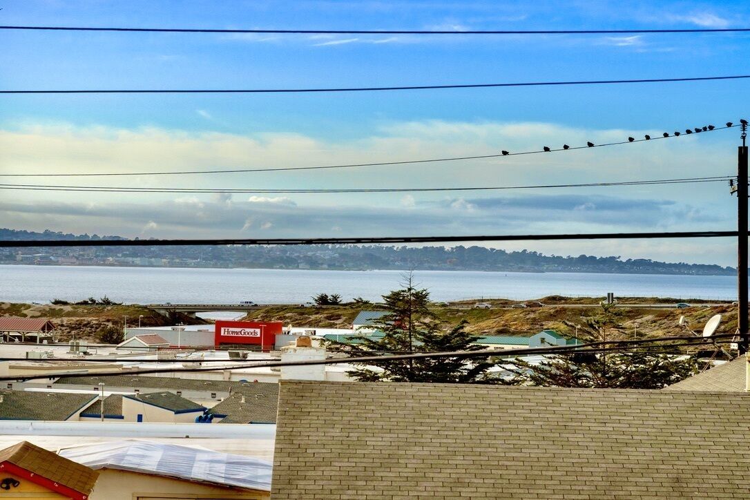 A coastal view with a clear sky, a distant shoreline, and a building with a red sign labeled "HomeGoods".
