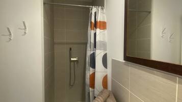 Een douche, een haardroger, handdoeken, toiletpapier