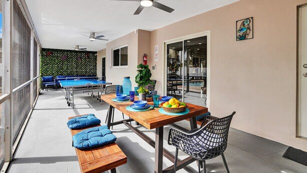 An outdoor patio with a pool table, seating, and a dining area.