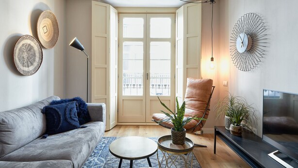 A living room with a sofa, armchair, coffee table, and TV.
