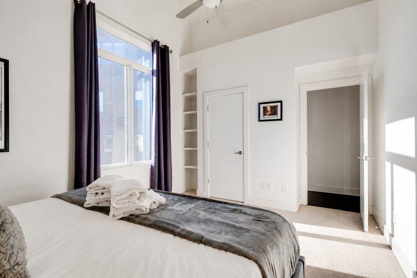A bedroom with a bed, a wardrobe, and a door leading to another room.