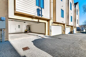 A multi-story residential building with a garage entrance, a visible water heater, and a clear sky.