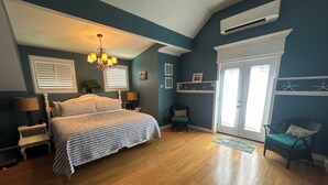 A bedroom with a bed, a chandelier, a chair, and a door. - 3 Bedroom House near Old Town (Bay St. Louis)