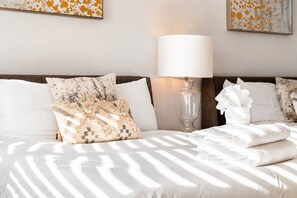 A hotel room with a bed, pillows, a lamp, and artwork on the wall. - 4BR townhome near The Gulch with rooftop skyline views (Nashville)