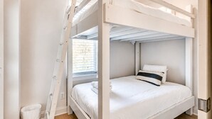 A bunk bed room with a ladder, a window with blinds, and a white door. - 4BR townhome near The Gulch with rooftop skyline views (Nashville)