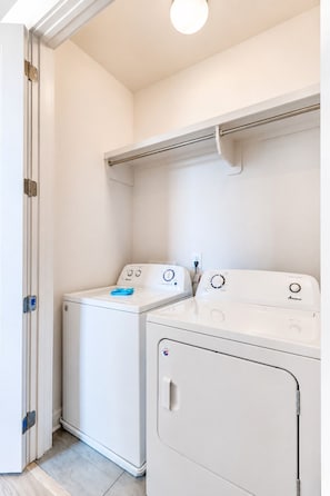 A laundry room with two white washing machines and a drying rack. - 4BR townhome near The Gulch with rooftop skyline views (Nashville)