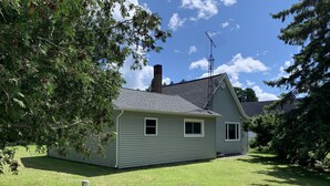 Ein eingeschossiges Haus mit schrägem Dach, Schornstein und Satellitenschüssel.