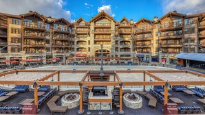 A multi-story hotel with outdoor seating and a central fire pit area. - Northstar Beauty Studio Condo in Heart of Resort (Truckee)