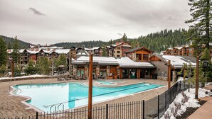 A resort with a swimming pool, wooden buildings, and a snowy landscape. - Northstar Beauty Studio Condo in Heart of Resort (Truckee)