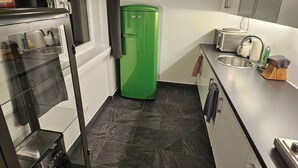 Eine kleine Küche mit Kühlschrank, Toaster und Spüle.