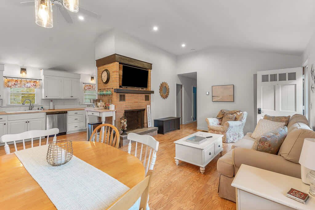 A spacious living area with a fireplace, a dining table, and a sofa.