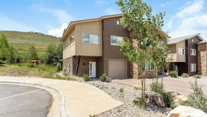 A multi-story residential building with a flat roof, large windows, and a stone facade. - Granby Colorful Adventures Breathtaking Views! (Granby)