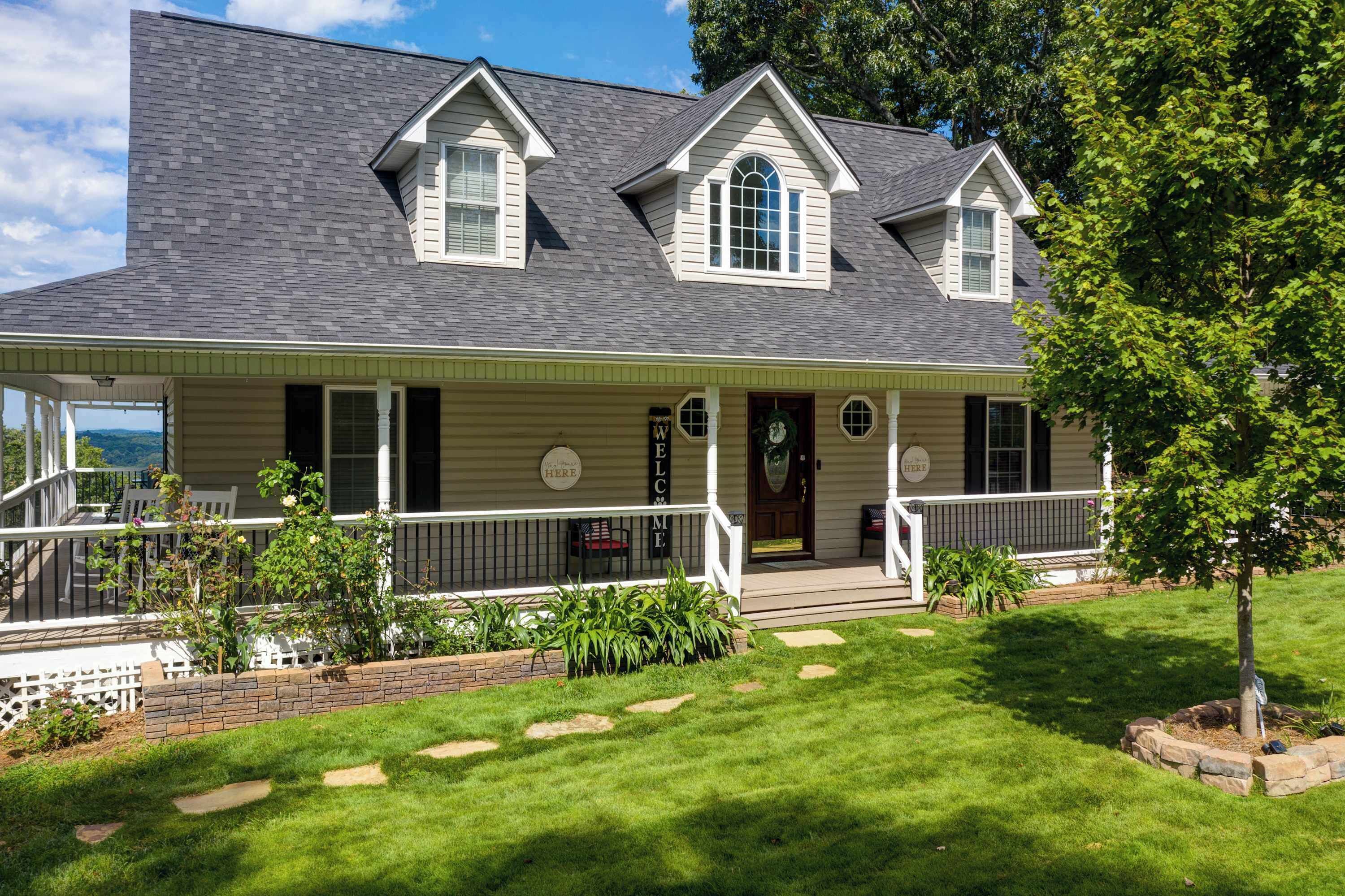A two-story house with a front porch, a covered patio, and a well-maintained lawn.
