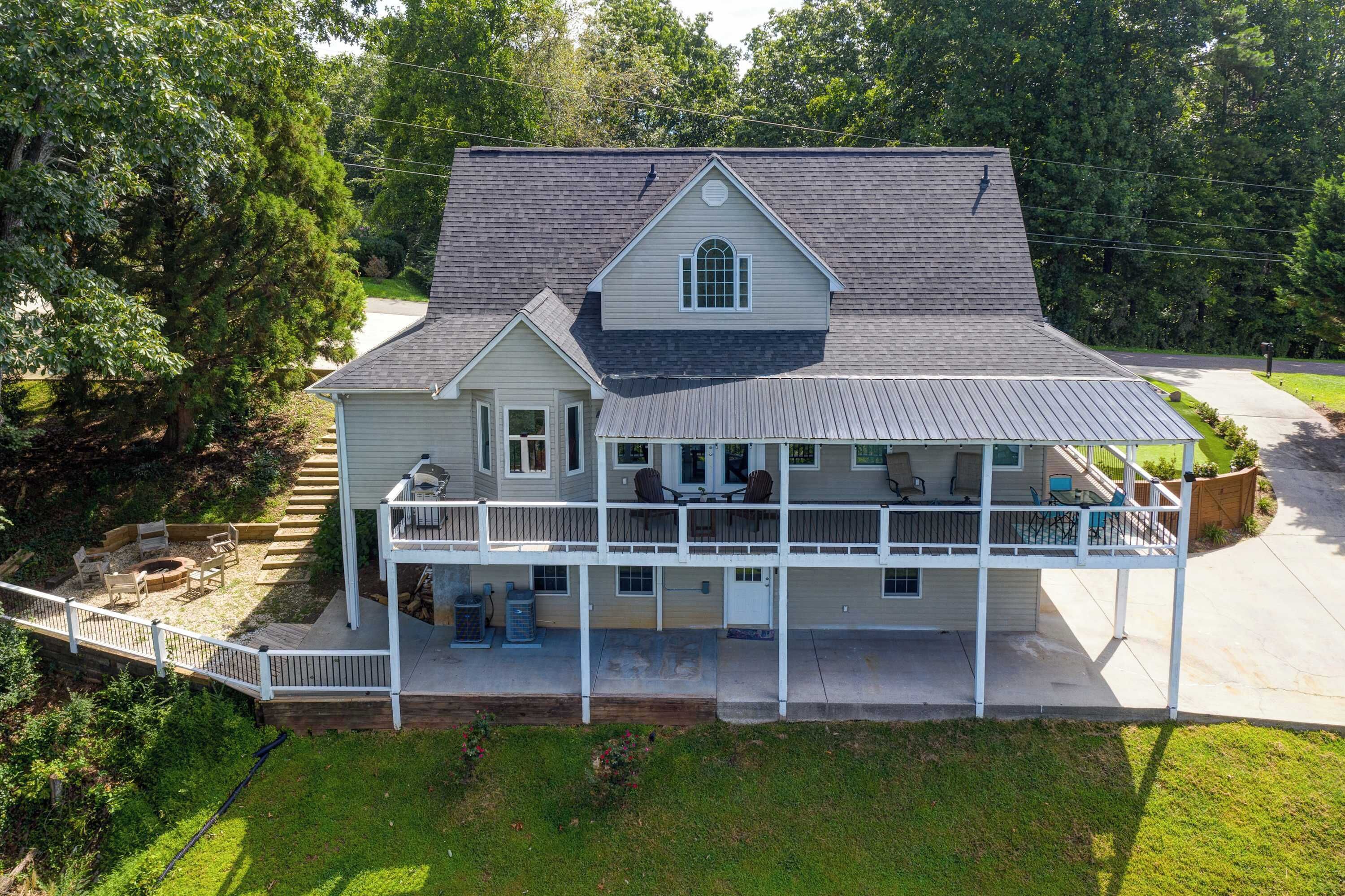 A two-story house with a covered porch and a deck.