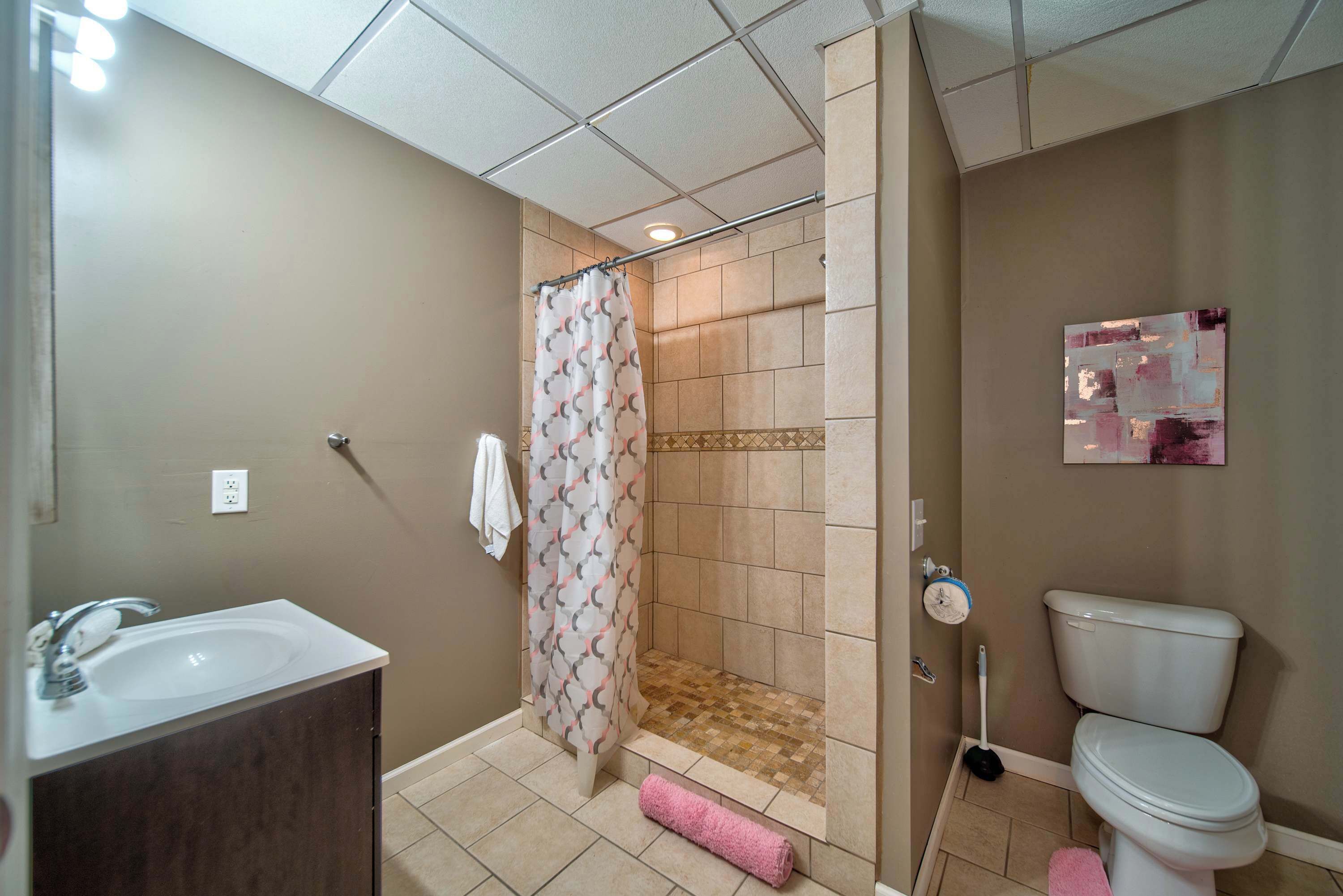 Une salle de bain équipée d’une douche, de toilettes, d’un lavabo et d’un porte-serviettes.