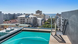 Una piscina en la azotea con vistas a la ciudad y al mar.