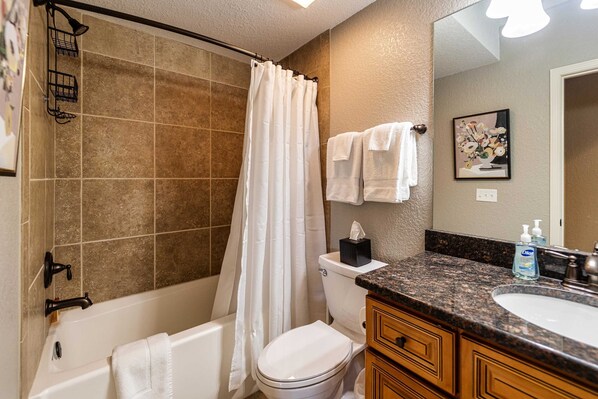 A bathroom with a bathtub, toilet, and sink.