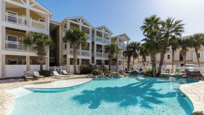 A hotel with a pool area, multiple balconies, and palm trees. - Resort Pool! 3 Bedroom ATV Optional Sleeps 10 (Corpus Christi)