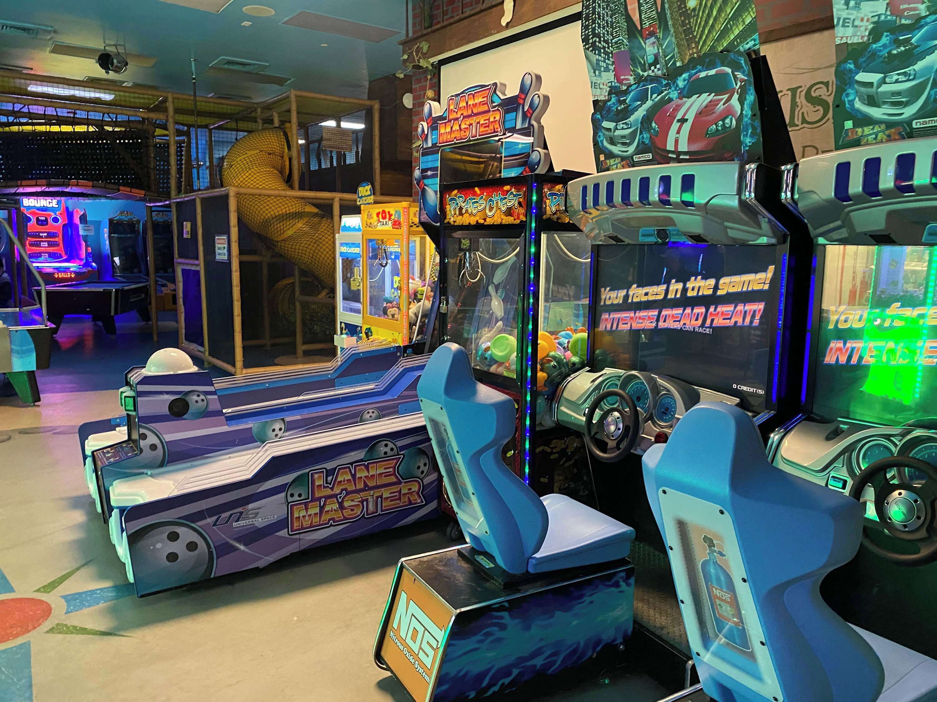 An arcade with various gaming machines, including 'Lane Master' and 'Intense Dead Heat' games.