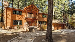 A log cabin with a stone staircase leading to the entrance, surrounded by trees. - Summit Pine Lodge 4 BDR Minutes From Bear Lake! (Big Bear Lake)
