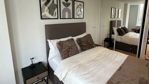 Ein Schlafzimmer mit Bett, Nachttisch und Wandbild.
