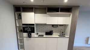 Eine moderne Küche mit weißen Schränken, einer Holz Arbeitsplatte und einem eingebauten Backofen.