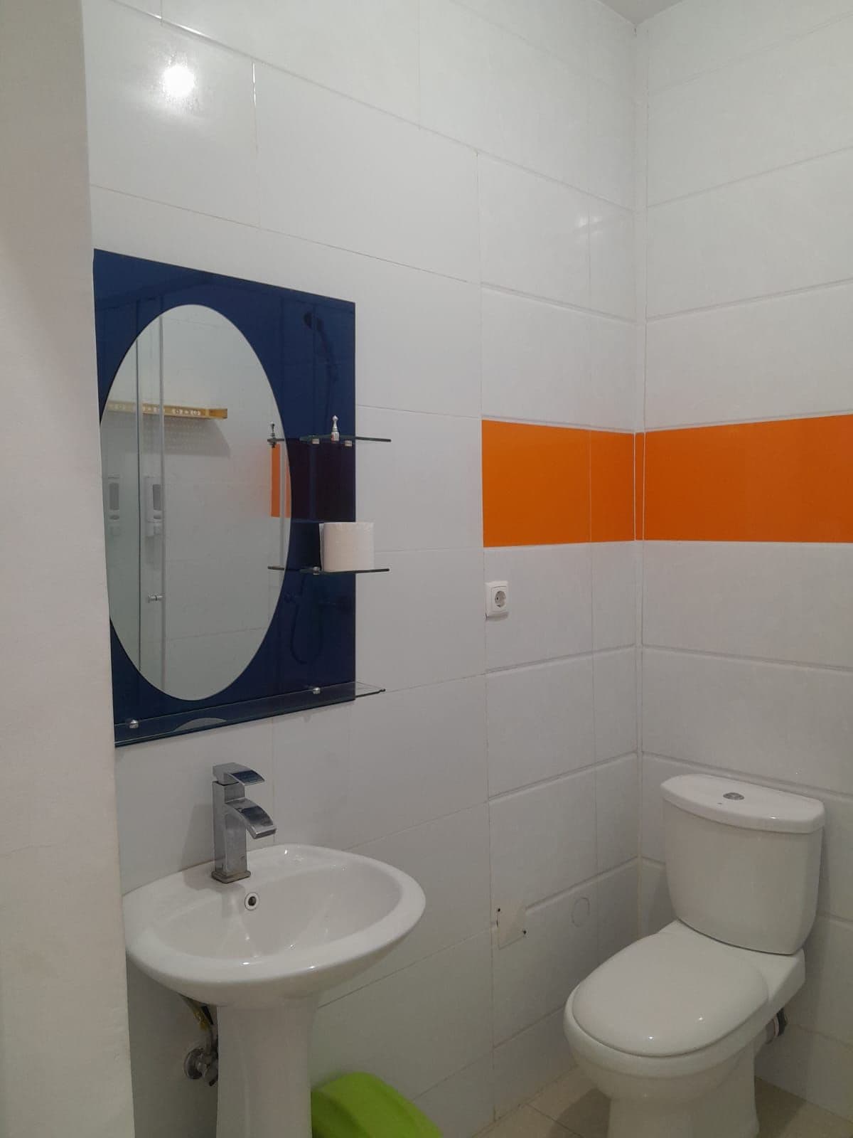 Un baño con un lavabo blanco, un espejo y un inodoro blanco.