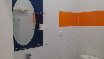 Un baño con un lavabo blanco, un espejo y un inodoro blanco.