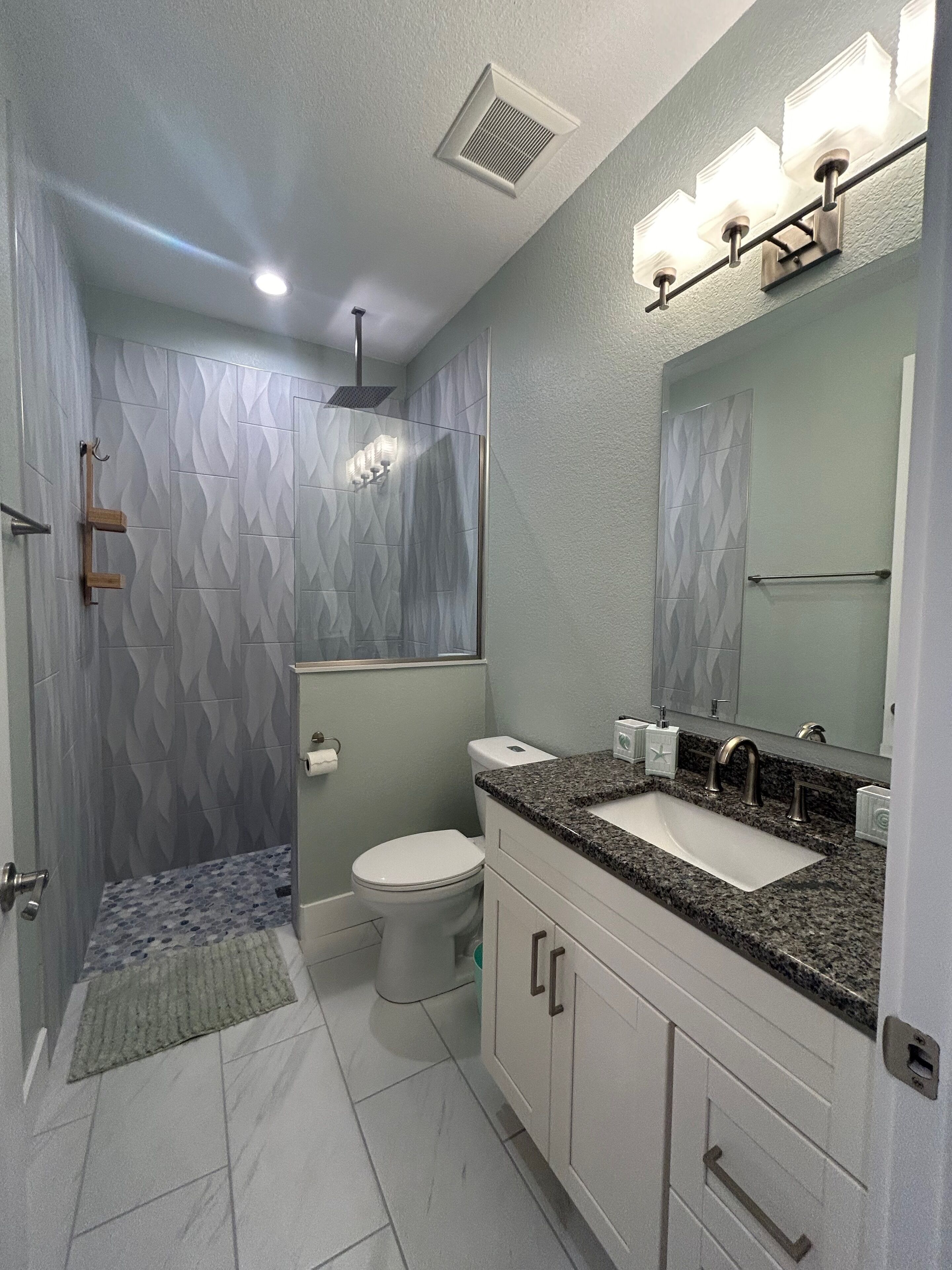 Un baño moderno con ducha, inodoro y tocador.