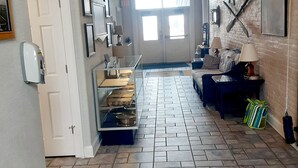 Un pasillo amplio con suelo de baldosas, un ventanal grande y una puerta que da a una habitación.