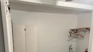 A bedroom with a bed, a patterned rug, a wardrobe, and a mirror. - tiny house backyard cabin getaway in Detroit (Detroit)