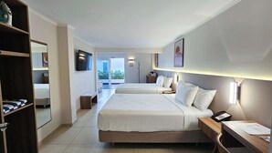 Habitación de hotel con dos camas, un escritorio, una silla, un armario y un televisor.