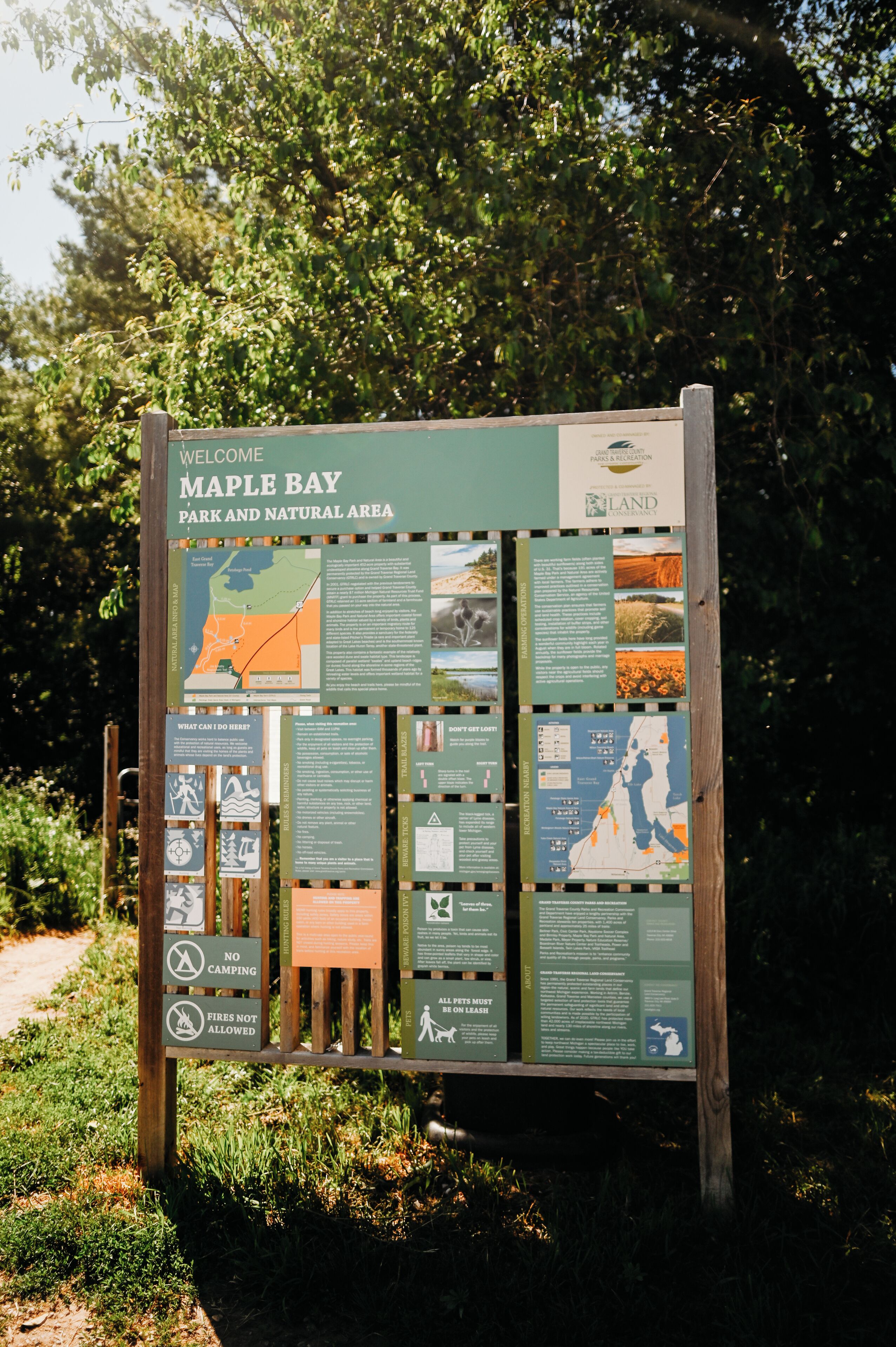 A welcome sign for Maple Bay Park and Natural Area with various informational panels.