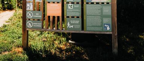 A welcome sign for Maple Bay Park and Natural Area with various informational panels.