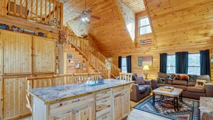 L’intérieur d’une cabane en bois comprend une cuisine, un coin repas et un salon.
