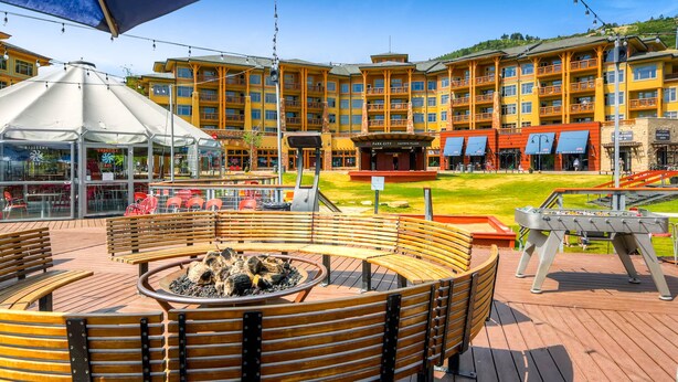Een hotel met een centrale binnenplaats, inclusief een vuurkorf, buiten zitplaatsen en een pooltafel.