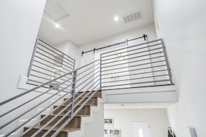 Una escalera moderna con barandillas metálicas y un interior blanco.
