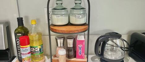 A kitchen counter with a wooden spice rack holding jars labeled 'Cream' and 'Sugar'.