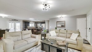 A spacious living room with two beige sofas, a coffee table, and a chandelier. - 5 Mi to Beach: Poolside Paradise in Lake Havasu! (Lake Havasu City)