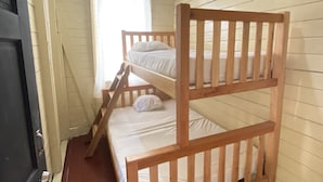 Una cama litera en una habitación con paredes de madera y una puerta.