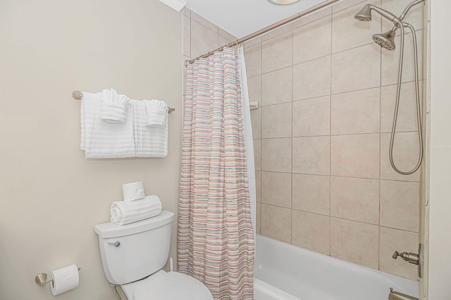 Un baño con ducha, inodoro y toallas.